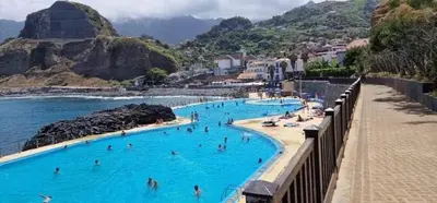 a group of people in a swimming pool on the beach at caminho da praia da maiata in Porto da Cruz