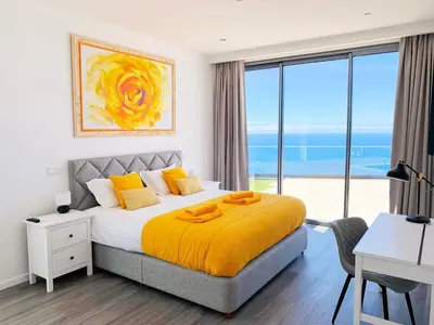 a bedroom with a large bed with a yellow blanket at Villa Céu e Mar in Prazeres
