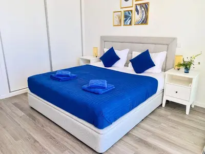 a bedroom with a bed with blue sheets and blue pillows at Villa Céu e Mar in Prazeres