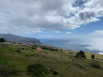 a green hill with the ocean in the background at Villa Céu e Mar in Prazeres