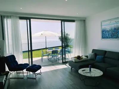 a living room with a couch and a table with an umbrella at Villa Céu e Mar in Prazeres
