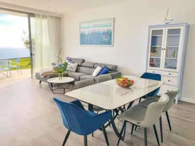 a living room with a table and chairs and a couch at Villa Céu e Mar in Prazeres