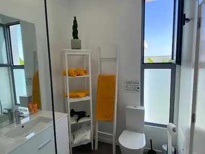 a bathroom with a sink and a toilet and a mirror at Villa Céu e Mar in Prazeres