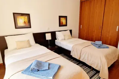 two beds in a hotel room with towels on them at Luxury apartment at Baia da Luz in Luz