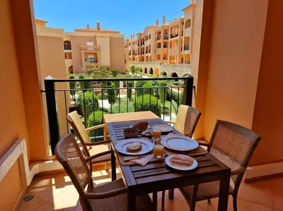 a table with plates of food on a balcony at Luxury apartment at Baia da Luz in Luz