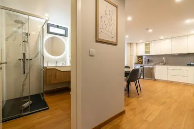 a room with a glass shower and a kitchen at Casa Paradiso in Arco da Calheta
