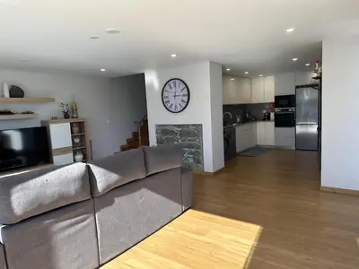 a living room with a couch and a clock on the wall at Casa Paradiso in Arco da Calheta