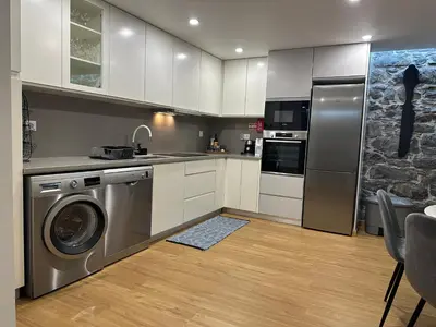 a kitchen with a stainless steel washer and dryer at Casa Paradiso in Arco da Calheta