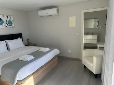 a bedroom with a large bed and a chair at Casa Paradiso in Arco da Calheta