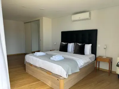 a bedroom with a large bed with a black headboard at Casa Paradiso in Arco da Calheta