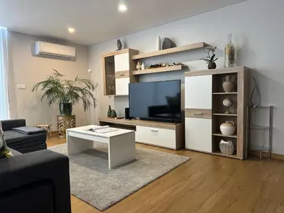 a living room with a television and a white entertainment center at Casa Paradiso in Arco da Calheta