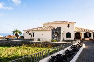 a white house with a fence in front of it at Namastê House II in Funchal