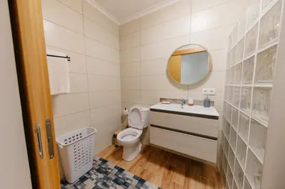 a bathroom with a toilet and a sink and a mirror at sweet home in Caniçal