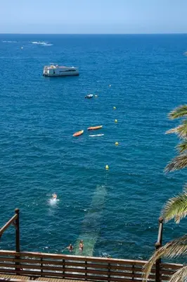 a boat in the ocean with people in the water at GuestReady - A sunny delight in Funchal in Funchal