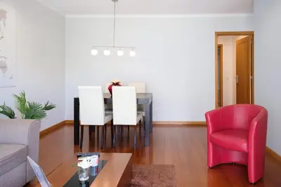 a living room with a table and a pink chair at GuestReady - A sunny delight in Funchal in Funchal