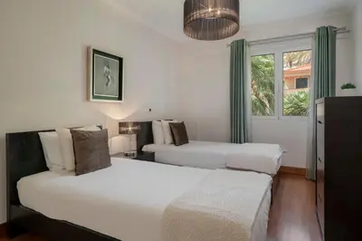 a bedroom with two beds and a window at Vila Formosa II by An Island Apart in Funchal