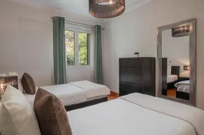 a bedroom with two beds and a mirror at Vila Formosa II by An Island Apart in Funchal