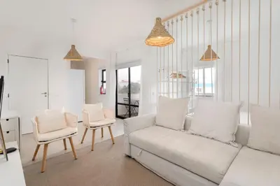 a living room with a white couch and two chairs at TAC - Sagres Studio in Sagres