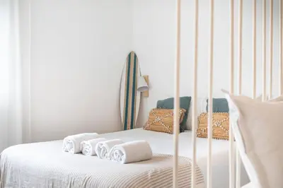 a white bed with four white towels on it at TAC - Sagres Studio in Sagres
