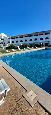 a swimming pool in front of a large building at TAC - Sagres Studio in Sagres