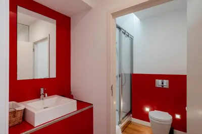 a red bathroom with a sink and a toilet at Pipas do Avô - Seixal by An Island Apart in Porto Moniz