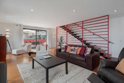 a living room with a couch and a staircase at Pipas do Avô - Seixal by An Island Apart in Porto Moniz