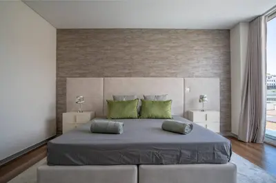 a bedroom with a large bed with green pillows at Freemont Apartment Funchal in Funchal
