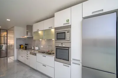 a kitchen with white cabinets and a microwave at Freemont Apartment Funchal in Funchal