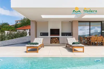a villa with a swimming pool and a dining area at OurMadeira - Calheta Pearl in Estreito da Calheta