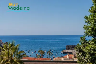 a view of a beach with people in the water at OurMadeira - Bayside in Câmara de Lobos