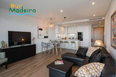a living room and kitchen with a couch and a table at OurMadeira - Bayside in Câmara de Lobos