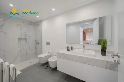 a white bathroom with a sink and a toilet at OurMadeira - Bayside in Câmara de Lobos
