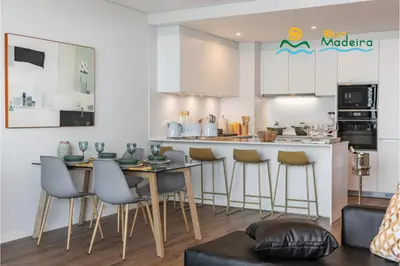 a kitchen with a table and chairs in a room at OurMadeira - Bayside in Câmara de Lobos
