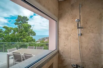 a shower room with a glass window and a table and chairs at Villa Azinhaga in Gaula