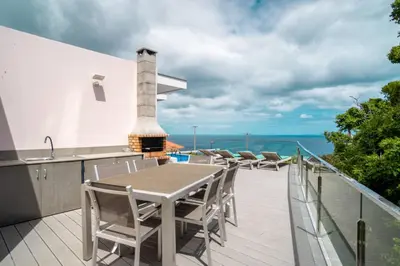 a bedroom with a large bed with a view of the ocean at Villa Azinhaga in Gaula