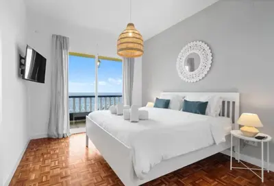 a bedroom with a bed and a view of the ocean at Casa do mar 2 bedrooms and kingsize bed in Ponta Delgada