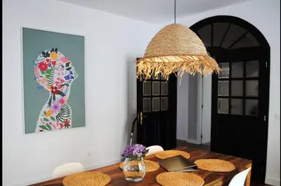 a table with a lamp and a vase of flowers at Casa do mar 2 bedrooms and kingsize bed in Ponta Delgada