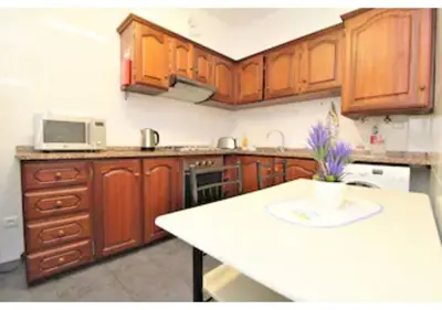 a kitchen with a table and a refrigerator at Casa Monte in Funchal