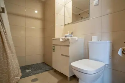 a bathroom with a white toilet and a mirror at Vista Vieira Apartments in Funchal