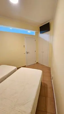 a small room with two beds and a door at Funchal Apartments - New Botanic Garden Petit Studios in Funchal