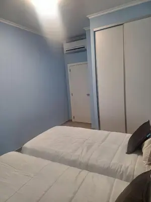 a bedroom with two white beds and a door at Funchal Apartments - New Botanic Garden Petit Studios in Funchal