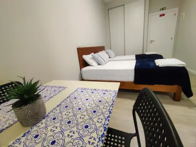 a bedroom with a bed and a table and chairs at Funchal Apartments - New Botanic Garden Petit Studios in Funchal