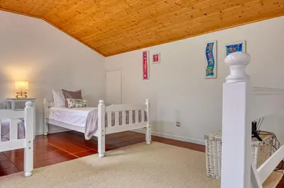 a bedroom with two beds and a wooden ceiling at Porto Santo Pip House, a Home in Madeira in Porto Santo