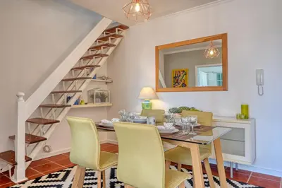 a dining room with a table and chairs and a staircase at Porto Santo Pip House, a Home in Madeira in Porto Santo