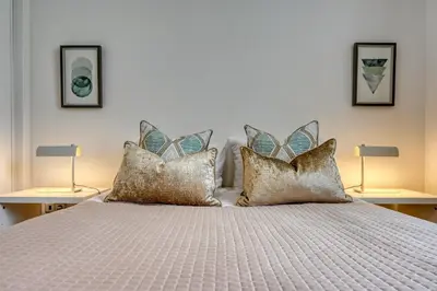 a bedroom with a bed with pillows and two lamps at Porto Santo Pip House, a Home in Madeira in Porto Santo