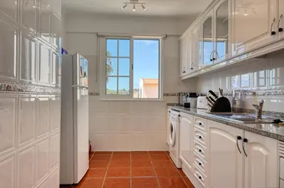 a kitchen with white cabinets and a window at Porto Santo Pip House, a Home in Madeira in Porto Santo