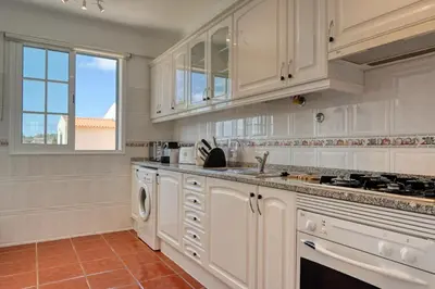 a kitchen with white cabinets and a sink at Porto Santo Pip House, a Home in Madeira in Porto Santo