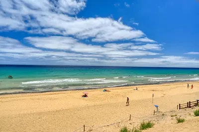 a beach with people on the sand and the ocean at Porto Santo Pip House, a Home in Madeira in Porto Santo