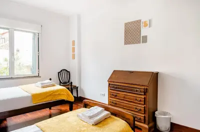 a bedroom with two twin beds and a dresser at A ver o mar rooms- Funchal city center in Funchal