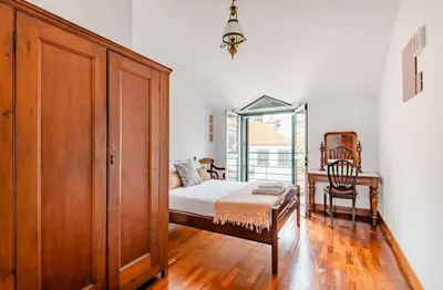 a bedroom with a bed and a cabinet and a chair at A ver o mar rooms- Funchal city center in Funchal